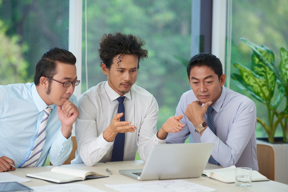 three-malaysian-office-men-discussing-credit-myths-in-front-of-a-laptop